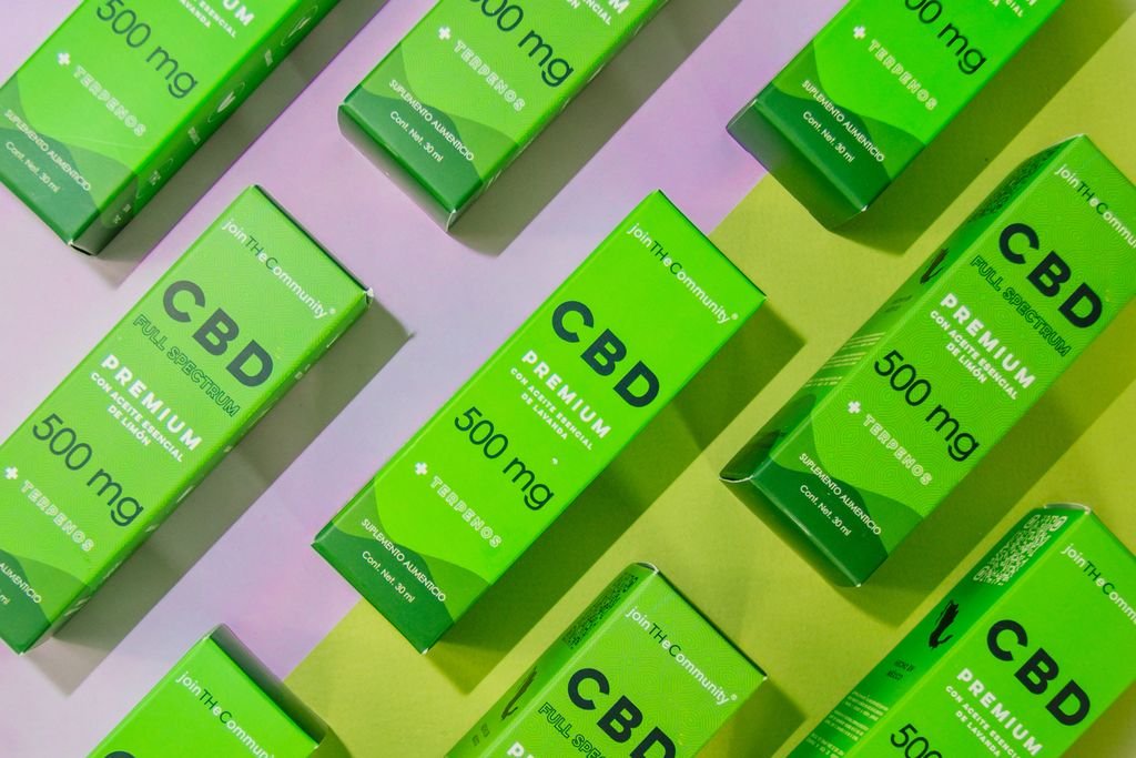 Array of CBD product boxes displayed on a vibrant colored surface. Ideal for retail and product design themes.